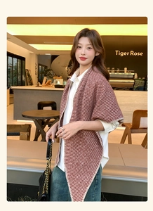 Detail of soft brown and beige houndstooth knit shawl draped over a white casual shirt