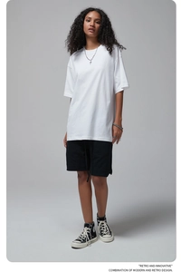 Detailed full body view of a white oversized cotton T-shirt and black shorts on a model