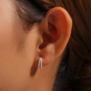 Close-up of minimalist S925 sterling silver huggie earring with double-row crystals on ear