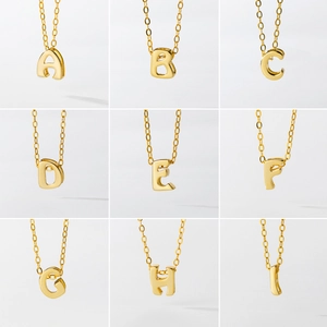 Polished gold S925 silver alphabet pendant necklaces set with thin chains on white background