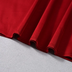 Détail du tissu en satin rouge avec coutures de qualité sur l'ourlet évasé de la robe