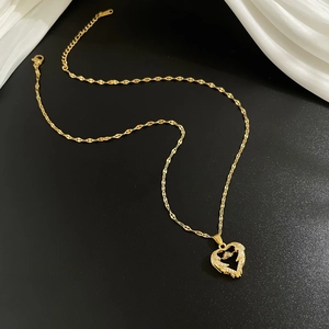 Elegant gold heart pendant necklace with shimmering crystals on a white satin background