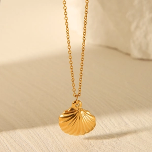 Detailed view of 3D shell pendant on fine golden chain with elegant shadows