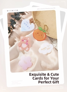 Flat lay of creative heart, bear, and fruit gift tags on silk with gold beaded chains