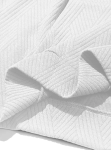 Close-up of white cotton blend knit fabric showing detailed herringbone twill texture