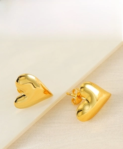 Detailed macro view of 18K gold plated heart stud earrings showing butterfly back clasps
