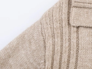 Macro shot of oatmeal knit sweater showing ribbing and premium textured stitching detail