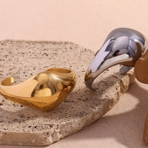 Detail of high-polished gold and silver cuff bracelets on stone and wood elements