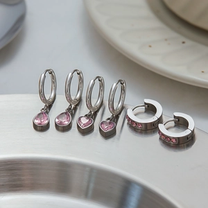 Detailed set of six silver zircon earrings with pink gemstones on a metal tray