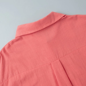 Detailed view of coral pink cotton linen shirt collar and box pleat back texture