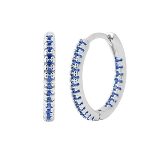 Close-up of silver earrings with small inlaid blue cubic zirconia crystals