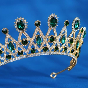 Detail of gold bridal crown featuring green emerald gemstones and sparkling rhinestones