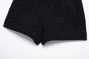 Détail d'un short en tweed noir avec texture mouchetée blanche et couture de qualité