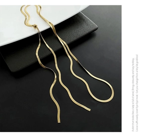Detail of adjustable gold snake chain necklace with flat polished metal links for women