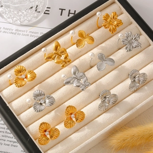Elegant 18k gold and silver pearl flower butterfly earrings on a velvet jewelry tray