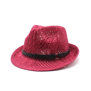 Detail of red knitted jazz hat with breathable hollow mesh texture and black metal ring band
