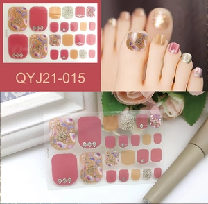 Detail of floral and gold glitter toe nail stickers with marble patterns and rhinestones