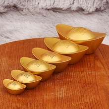 Set of 6 golden brass ingots in various sizes on a wooden and plush surface