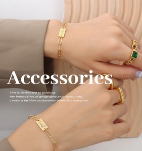 Dettaglio del bracciale placcato oro 18K con targhetta Lucky e anello con smeraldo