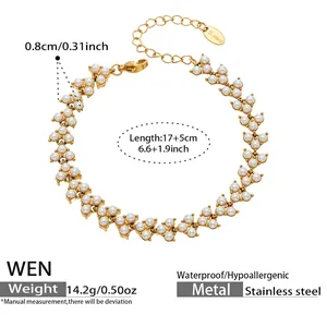 Détail du bracelet en acier inoxydable doré avec perles blanches et logo S.steel
