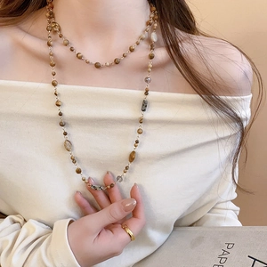 Close-up of double-layered beaded necklace with natural tiger eye stones and gold accents
