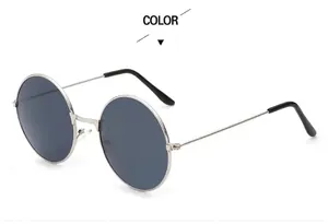 Detail view of round silver metal frame sunglasses with gray lenses and black temple tips