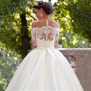 Elegant white lace off-shoulder wedding dress with button back detail and satin train