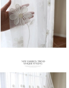 Détail d'un rideau en dentelle blanche avec broderie florale délicate et texture légère