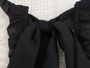 Détail du nœud papillon noir élégant sur bandoulière en tulle blanc pour blouse française