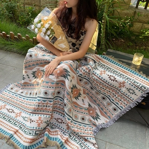 Détail d'une couverture tissée bohème avec motifs solaires géométriques et franges