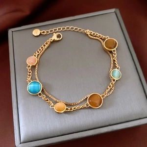 Detailed macro view of 18k gold plated bracelet with multi-colored opal stones on a jewelry box