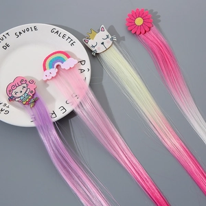 Detail of colorful kids hair extensions featuring mermaid, rainbow, and crown motifs
