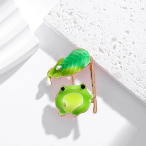 Détail d'une broche grenouille en émail sous une feuille avec finition lisse polie