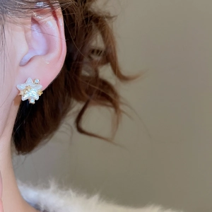 Gros plan de boucles d'oreilles étoiles avec placage en or 14k, perles et zircons