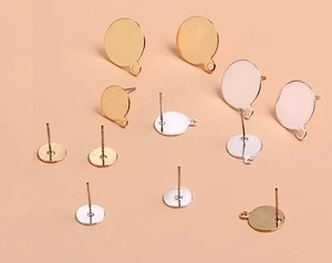 Flat lay of gold and silver DIY earring posts with round flat pads and small side loops