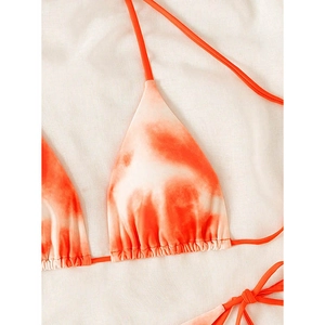 Detailed top view of orange and white tie-dye triangle bikini top with drawstring ties