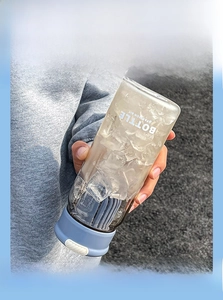 Close-up of leakproof blue lid and clear plastic water bottle with ice and printed text
