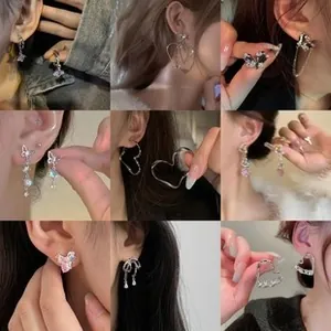 Collage of butterfly tassel earrings and heart studs in silver finish on a model