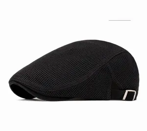 Close-up of black breathable mesh flat cap featuring silver metal logo and side texture