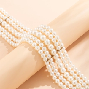 Detailed close-up of multi-layer white pearl choker necklace with silver spacers