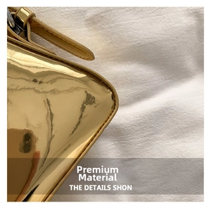Close-up detail of glossy metallic underarm bag with smooth mirror finish and stitching