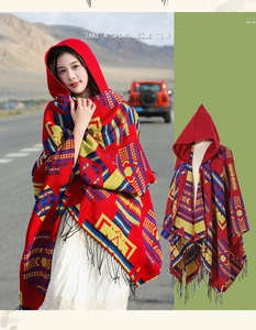 Detail of red ethnic hooded poncho with geometric patterns and fringe for outdoor travel