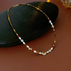 Detailed shot of tiger eye beads and pearls necklace on black velvet display box