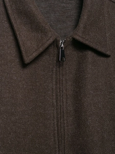 Détail macro d'une veste marron foncé en laine avec col à revers et fermeture éclair