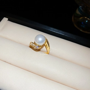 Vue macro d'une bague serpent plaquée or avec perle ronde et oxydes de zirconium brillants