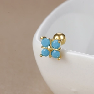 Detailed close-up of a gold-plated cross stud earring with turquoise beads and screw back