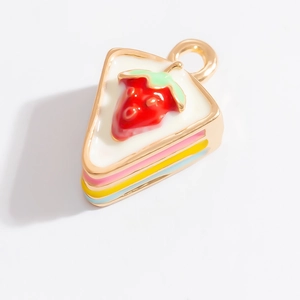 Gros plan détaillé d'un pendentif gâteau aux fraises 3D avec couches colorées et base dorée