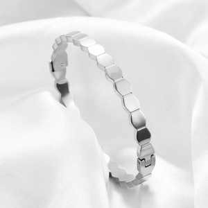 Macro shot of silver hexagonal honeycomb bangle showing the polished mirror finish and clasp