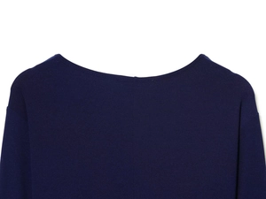 Close-up of the fine texture on a dark blue knitted top neckline and shoulder details