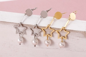 Gros plan de boucles d'oreilles étoiles en or et argent avec perles blanches